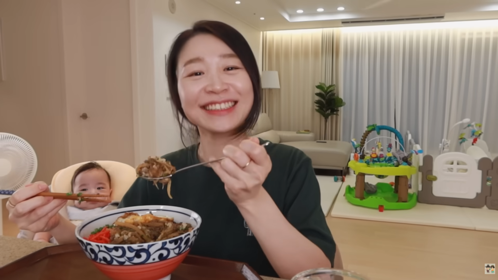 Claire smiling with a plate of their homemade Gyudon