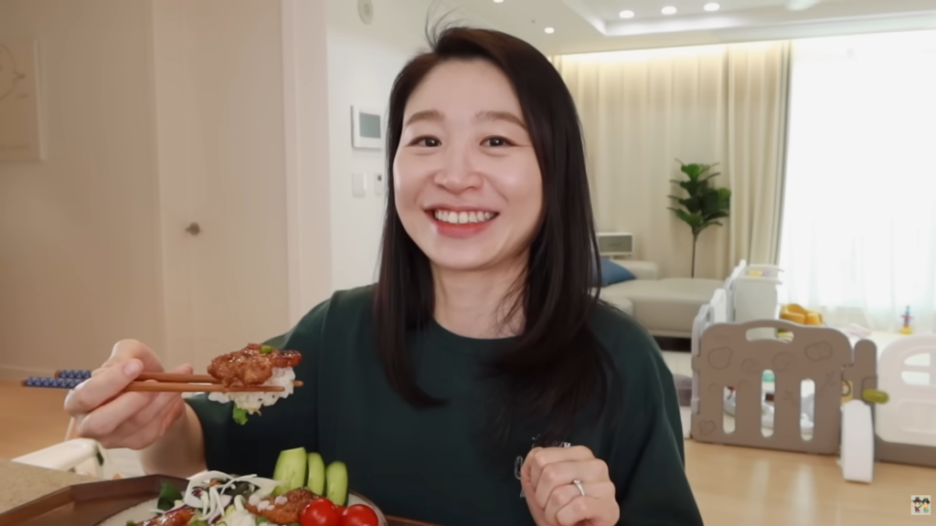 Claire smiling with a plate of their homemade Soy-Glazed Pork Belly